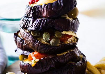 Aubergine-kebab-stacked-tomatoes-olives-cheese-chips-close-up-chips